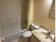 Bathroom features a bathtub with shower, a toilet, and vanity with ample lighting at 333 Lake Howard Nw Dr # 103C, Winter Haven, FL 33880