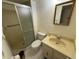 Bathroom with tiled shower, toilet, and vanity sink with decorative mirror at 333 Lake Howard Nw Dr # 103C, Winter Haven, FL 33880