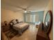 Bedroom featuring a comfortable bed, ceiling fan, accent chair, and tile floors at 333 Lake Howard Nw Dr # 103C, Winter Haven, FL 33880