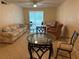 Open living room with comfortable seating, glass tables, tile floor, and ceiling fan at 333 Lake Howard Nw Dr # 103C, Winter Haven, FL 33880