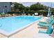 Community pool area with lounge chairs and tables at 333 Lake Howard Nw Dr # 103C, Winter Haven, FL 33880