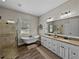 Bright bathroom features a clawfoot tub, glass shower, and double vanity with granite countertop at 3805 Mammoth Grove Rd, Lake Wales, FL 33898