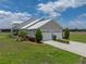 Exterior side view of a home featuring a metal roof, well-manicured lawn, and three-car garage at 3805 Mammoth Grove Rd, Lake Wales, FL 33898