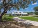 Attractive single-story home with a metal roof, lush lawn, circular driveway, and mature shade trees at 3805 Mammoth Grove Rd, Lake Wales, FL 33898