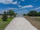 Detached garage with gravel driveway and covered awning, offering ample storage and parking space at 3805 Mammoth Grove Rd, Lake Wales, FL 33898