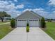 Exterior view of the garage featuring three garage doors, a well manicured lawn, and driveway at 3805 Mammoth Grove Rd, Lake Wales, FL 33898