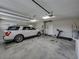 Spacious garage with tall ceilings, a vehicle, a treadmill, and room for storage and activities at 3805 Mammoth Grove Rd, Lake Wales, FL 33898