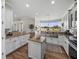 Kitchen featuring an island, white cabinets, granite counters, and a large picture window at 3805 Mammoth Grove Rd, Lake Wales, FL 33898
