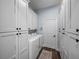 Modern laundry room is equipped with white cabinets and washer and dryer units at 3805 Mammoth Grove Rd, Lake Wales, FL 33898