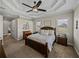 Bedroom with neutral walls, a dark wood bed frame, and views of the grassy landscape at 3805 Mammoth Grove Rd, Lake Wales, FL 33898