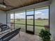 Screened-in back patio, showcasing an outdoor view of green pastures, with brick floors and comfortable seating at 3805 Mammoth Grove Rd, Lake Wales, FL 33898