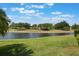 Beautiful backyard with a lake view, lush green grass, and mature trees at 3844 Bedford Ave, Winter Haven, FL 33884