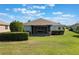 Well-maintained backyard with green lawn, neat hedges, and a covered, screened-in lanai at 3844 Bedford Ave, Winter Haven, FL 33884