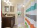 Bright bathroom features a granite countertop, tile floors, and colorful shower curtain at 3844 Bedford Ave, Winter Haven, FL 33884