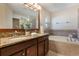 Bathroom with double sinks, granite countertops, and a soaking tub at 3844 Bedford Ave, Winter Haven, FL 33884