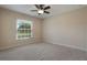 Bright bedroom featuring a ceiling fan, neutral carpet, and natural light from the window at 3844 Bedford Ave, Winter Haven, FL 33884
