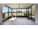 Spacious lanai with tiled flooring and a serene view of the lake and fountain at 3844 Bedford Ave, Winter Haven, FL 33884