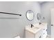 Bright bathroom with white cabinets, dual sinks, round mirrors, and matte black fixtures at 404 Miami Way, Kissimmee, FL 34759