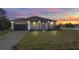 Inviting single-story home with a well-maintained lawn and a two-car garage at sunset at 404 Miami Way, Kissimmee, FL 34759
