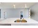 Close-up of a kitchen island with a double sink, quartz countertop, and contemporary pendant lights at 404 Miami Way, Kissimmee, FL 34759