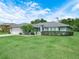 Attractive single-story home with a lush front lawn, trimmed hedges, and a two-car garage at 409 N 6Th St, Lake Hamilton, FL 33851