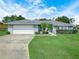 Charming single-story home featuring a well-manicured lawn and an attached two-car garage at 409 N 6Th St, Lake Hamilton, FL 33851
