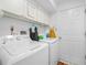 Bright laundry room features a washer and dryer, storage cabinets, and convenient access door at 409 N 6Th St, Lake Hamilton, FL 33851