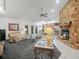 Comfortable living room featuring a stone fireplace, neutral carpeting, and a view into the adjacent kitchen at 409 N 6Th St, Lake Hamilton, FL 33851
