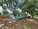 Single-story home with light blue exterior paint and mature trees and landscaping in the front yard at 4211 Sunny Land Dr, Lakeland, FL 33813