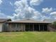 Low angle exterior shot of home with back enclosed patio, on a large lot with blue sky at 426 Gleneagles Ct, Winter Haven, FL 33884