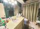 Bathroom with a single sink vanity and bath-shower combination with green striped wallpaper at 426 Gleneagles Ct, Winter Haven, FL 33884