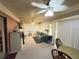 Spacious carpeted living room with ceiling fans, a sofa and a table with chairs at 426 Gleneagles Ct, Winter Haven, FL 33884