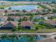 An aerial view of homes in a community near a pond and featuring well-maintained landscaping and screened-in patios at 4327 Gullane Dr, Lake Wales, FL 33859