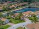 Aerial view of a charming home in a well-maintained community with mature trees and a nearby pond at 4327 Gullane Dr, Lake Wales, FL 33859