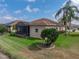 Well-maintained backyard featuring a screened-in patio, verdant lawn, mature landscaping, and palm trees at 4327 Gullane Dr, Lake Wales, FL 33859