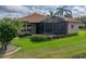 The backyard exterior features a screened lanai, manicured lawn, and mature palm trees at 4327 Gullane Dr, Lake Wales, FL 33859