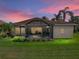 The exterior back of home features a screened lanai, palm trees and a manicured lawn at 4327 Gullane Dr, Lake Wales, FL 33859