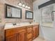 Bathroom featuring double sinks, mirrors, tiled walls plus flooring, and a window at 4327 Gullane Dr, Lake Wales, FL 33859