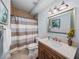 Well-lit bathroom featuring tiled floors, a shower/tub combo, and a vanity with a marble countertop at 4327 Gullane Dr, Lake Wales, FL 33859