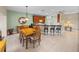 View of dining area with wooden table set, breakfast bar, and modern lighting fixture at 4327 Gullane Dr, Lake Wales, FL 33859