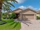 Inviting home exterior featuring a brick driveway, manicured lawn, and mature landscaping at 4327 Gullane Dr, Lake Wales, FL 33859