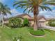 Charming home with a well-manicured lawn, mature palm trees, and a brick driveway under blue skies at 4327 Gullane Dr, Lake Wales, FL 33859