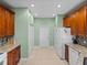Kitchen with white appliances, light green walls, and tile flooring at 4327 Gullane Dr, Lake Wales, FL 33859