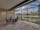 A covered and screened in lanai overlooking a pond with an outdoor table and chairs at 4327 Gullane Dr, Lake Wales, FL 33859
