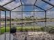 The screened in lanai with seating area overlooks a scenic water view at 4327 Gullane Dr, Lake Wales, FL 33859