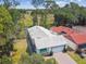 Aerial view of the home with a white roof and green awnings, nestled among lush greenery at 441 San Jose Dr, Winter Haven, FL 33884