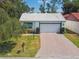 View of home's facade, with brick driveway, white garage door, and mature landscaping at 441 San Jose Dr, Winter Haven, FL 33884