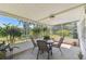 Screened-in lanai with outdoor dining set with views of the lush greenery, perfect for relaxation and entertaining at 441 San Jose Dr, Winter Haven, FL 33884
