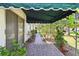 Landscaped walkway with a green awning and flowering plants along the side of the home at 441 San Jose Dr, Winter Haven, FL 33884