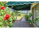 Landscaped walkway with a green awning and flowering plants along the side of the home at 441 San Jose Dr, Winter Haven, FL 33884